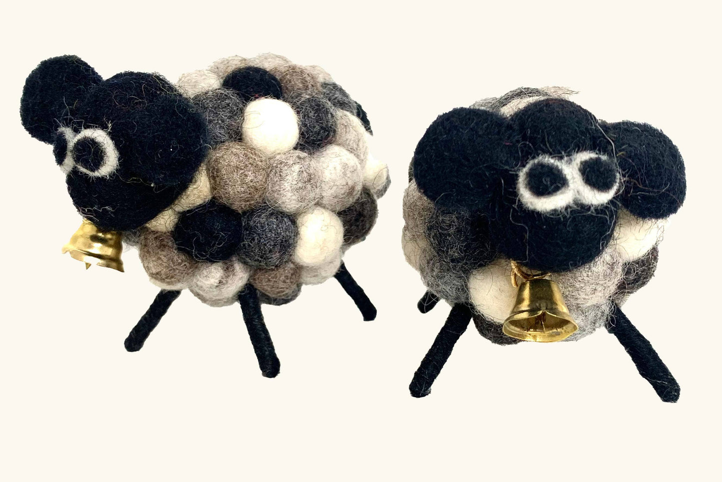 Two felted sheep ornaments with bells on a white background