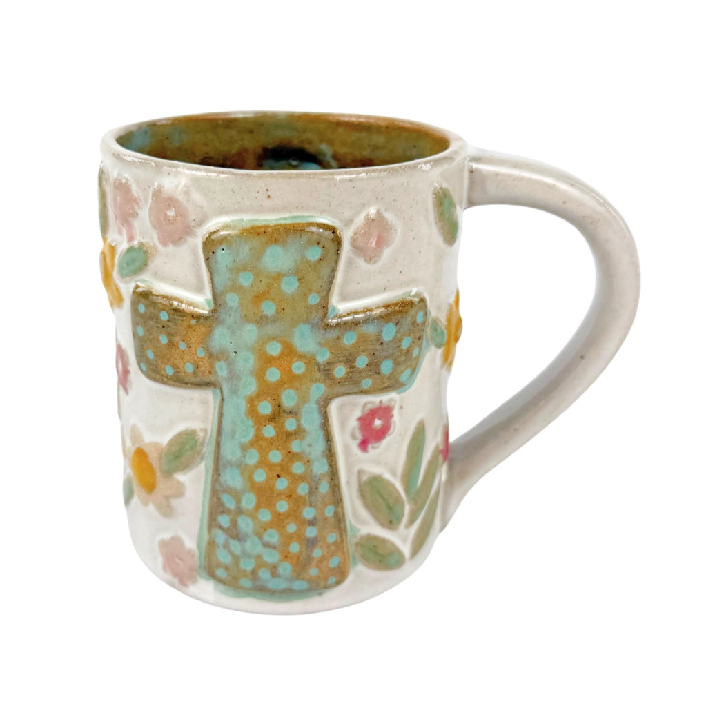 Ceramic mug 16 ounce with teal cross on sides. Neutral colors and flowers