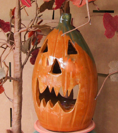 Jack o lantern happy cut out face for candle, battery or electric lights. Indoors or outdoor decor for Fall, Thanksgiving, and Halloween. Pottery lantern.